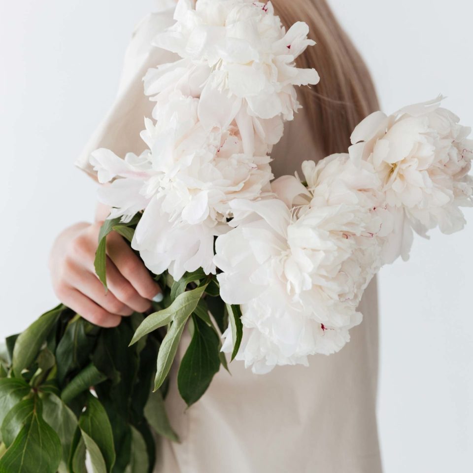 blonde-woman-standing-isolated-holding-flowers-P8B3XEP-1-scaled.jpg